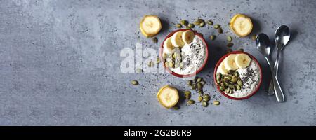 Ciotole con budino di chia con banana e semi di zucca. Foto Stock