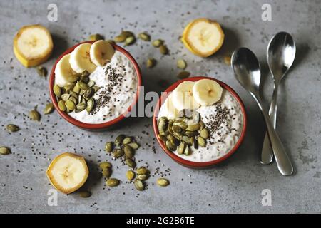 Ciotole con budino di chia con banana e semi di zucca. Foto Stock