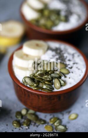 Ciotole con budino di chia con banana e semi di zucca. Foto Stock