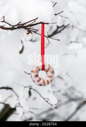 Torta di sueto fatta in casa con ciambelle di arachidi appesa nel giardino innevato. Nutrire gli uccelli in inverno. Spazio di copia. Foto Stock