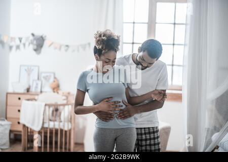 Felice uomo che tocca il ventre con le sue palme Foto Stock