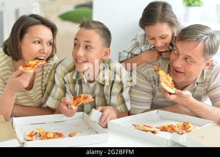 La famiglia felice di mangiare la pizza insieme in autunno park Foto Stock