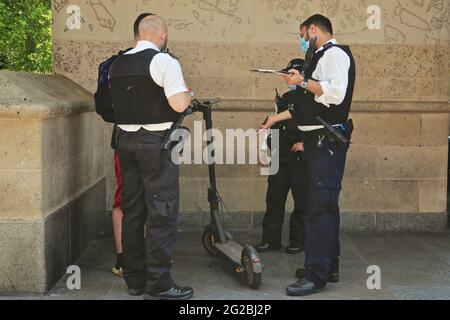 Londra (Regno Unito), 5 giugno 2021: La polizia si impura e colpisce uno scooter elettrico che è stato presumibilmente guidato attraverso semafori rossi nel quartiere Mayfair di Londo Foto Stock