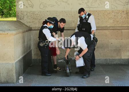 Londra (Regno Unito), 5 giugno 2021: La polizia si impura e colpisce uno scooter elettrico che è stato presumibilmente guidato attraverso semafori rossi nel quartiere Mayfair di Londo Foto Stock