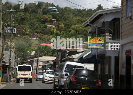 Victoria St Mark Grenada Street Scene Ambulance on Road e le auto parcheggiate all'esterno del Kelly's Hot Spot Restaurant Foto Stock