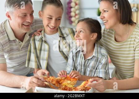 La famiglia felice di mangiare la pizza insieme in autunno park Foto Stock