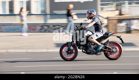 Belgrado, Serbia - 5 giugno 2021: Giovane uomo in moto veloce indossando pantaloncini e un protettore per la schiena , in città in una giornata di sole Foto Stock