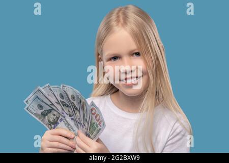 Ragazza che tiene un centinaio di dollari bollette nelle sue mani Foto Stock
