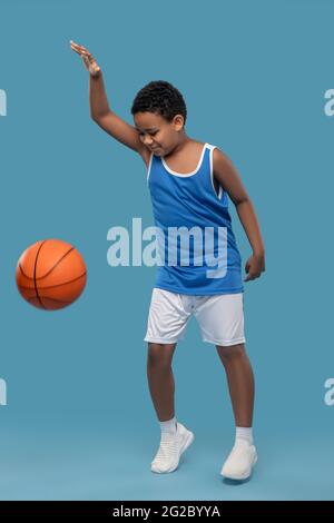 Ragazzo con pelle scura in palla sportiva Foto Stock