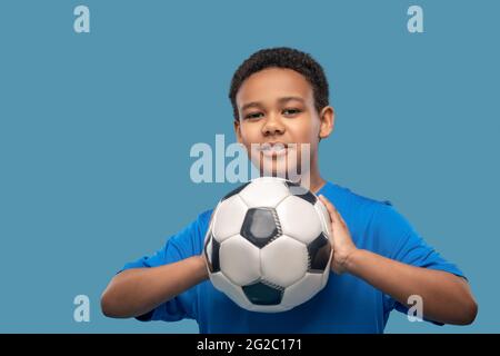 Ragazzo attento che prende mira con la palla in mano Foto Stock