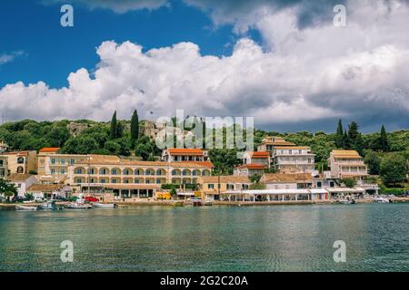 Isola di Corfù/Grecia - 6 maggio 2019: Vista sul bellissimo villaggio di Kassiopi - case, porto con barche colorate, laguna di mare con acque turchesi calme, antie Foto Stock