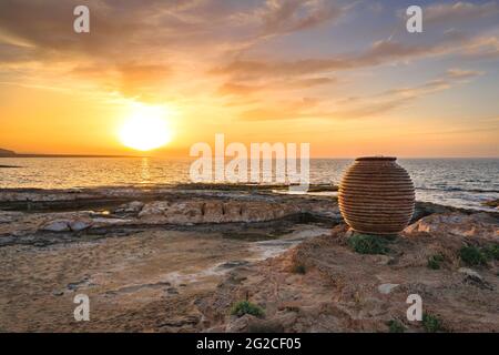 Una grande pentola al tramonto sulla spiaggia di Potamos a Malia, Creta, Grecia. Foto Stock