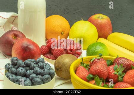 La frutta è posata sulla tavola di frullato di frutta. Cocktail di frutta con frutti di bosco su un tavolo di legno. Sfondo con spazio per il testo Foto Stock