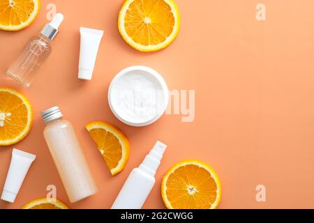 Vista dall'alto degli agrumi organici naturali e delle fette arancioni. Prodotti di bellezza in Vitamina C a giacitura piatta. Cura della pelle del viso. Foto Stock