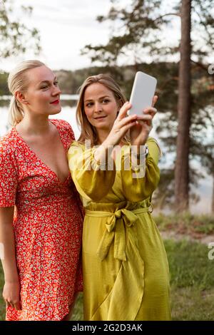 Amici di sesso femminile prendendo selfie con smart phone Foto Stock