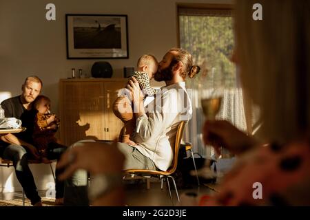 Padri con i loro bambini che riposano in soggiorno Foto Stock