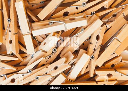 Stenopini di legno di fondo. I clothespins sono impilati uno sopra l'altro su una superficie bianca. Foto Stock