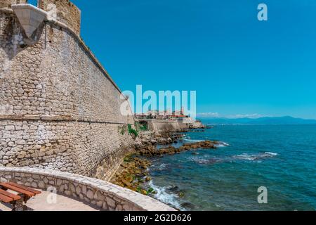 Fortezza e una scala in pietra, che va in mare. Molte grandi e piccole rocce e onde di mare che colpiscono le rocce. Blu mare onde sfondo e cielo bellissimo paesaggio. Foto di alta qualità Foto Stock