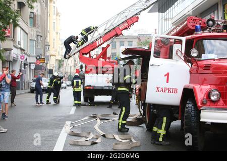 KHARKIV, UCRAINA - 10 GIUGNO 2021 - i motori del fuoco sono parcheggiati durante le esercitazioni tattiche speciali del servizio di emergenza di Stato fuori di uno shopping locale Foto Stock