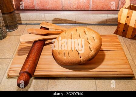 delizioso pane artigianale appena sfornato, nutriente, fatto in casa, farina di grano fresca e sana, su una tavola di legno, vista dall'alto da vicino. Foto Stock