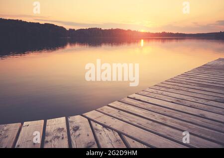 Molo in legno al lago Lipie al tramonto, fuoco selettivo, tonalità colore applicato, Strzelce Krajenskie, Polonia. Foto Stock