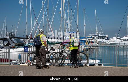 Yarmouth, Isola di Wight, Inghilterra, Regno Unito. 2021. I ciclisti anziani si affacciano sul porto di Yarmouth, sul lato nord dell'isola di Wight, una famosa re Foto Stock