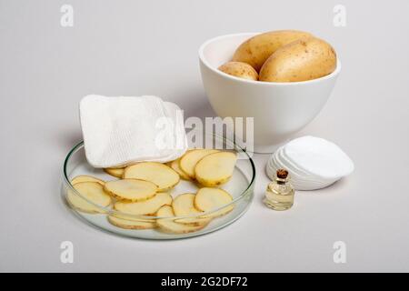 Patate a fette preparate per le procedure cosmetiche. Patate - un ingrediente di bellezza stupefacente. Trattamento fatto in casa. Foto Stock