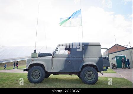 Un ragazzo siede in un classico Landrover Defender dell'esercito presso l'Imperial War Museum Foto Stock