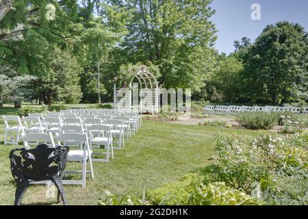 Sedie predisposte per un matrimonio in giardino Foto Stock