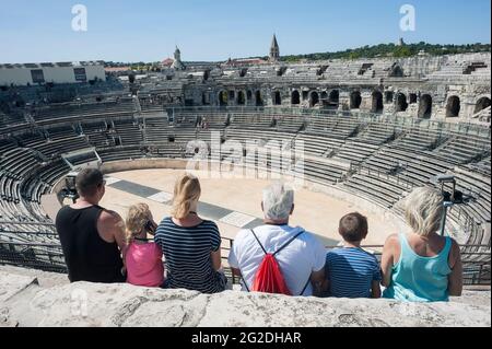 Turisti che guardano all'Arena di Nîmes nel sud della Francia Foto Stock