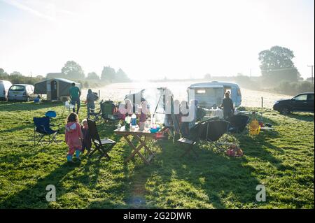 Famiglia e amici che si divertano con una carovana e un campeggio staycation viaggio Foto Stock