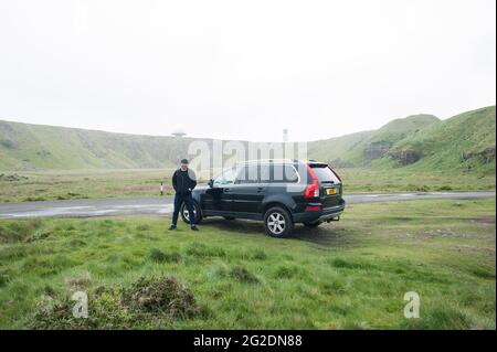 Un uomo si trova accanto alla sua auto Volvo XC90 4x4 nel paesaggio Foto Stock