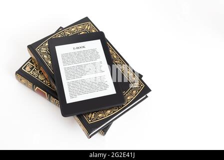 Lettore e-book con composizione di libri tradizionali. Lettura di libri con il concetto di dispositivo e-book Foto Stock