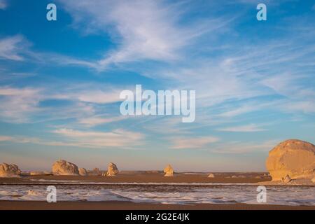 Enormi formazioni rocciose di gesso sotto il cielo blu al tramonto, deserto Bianco, Farafra, Egitto Foto Stock