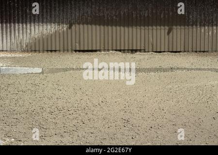 Cemento liquido ad un luogo di costruzione. Il cemento si è versato sulla strada. Il materiale da costruzione è cemento e ghiaia. Foto Stock