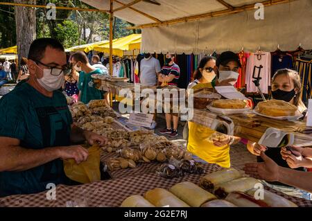 Tenda da stalla con biscotti, torte e dolci in vendita con i clienti in Alto Fair situato in piazza Higino da Silveira, quartiere Alto. Foto Stock