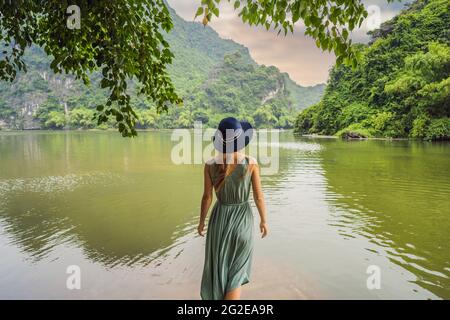 Donna turistica in Trang un complesso paesaggistico paesaggistico paesaggistico nella provincia di Ninh Binh, Vietnam UN sito patrimonio dell'umanità dell'UNESCO. Ripresa del turismo in Vietnam dopo Foto Stock