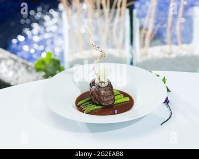 Gustoso filetto mignon su un letto di asparagi in salsa al pepe nero. Foto Stock