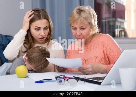 Due donne sono perplessi di problemi con il riempimento delle bollette di utilità con il laptop Foto Stock