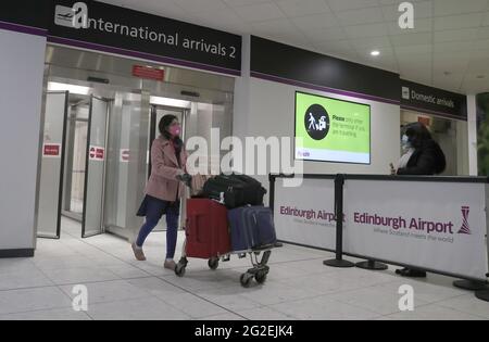 File foto datata 14/2/2021 di un passeggero che passa attraverso gli arrivi internazionali all'aeroporto di Edimburgo. Gli aeroporti del Regno Unito hanno perso 223 milioni di passeggeri lo scorso anno a causa della pandemia del coronavirus, i dati mostrano. Circa 74 milioni di passeggeri hanno viaggiato attraverso gli aeroporti del Regno Unito nel 2020, ha rivelato l'analisi dei dati dell'autorità per l'aviazione civile da parte dell'agenzia di stampa PA. Data di emissione: Venerdì 11 giugno 2021. Foto Stock