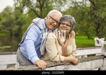 Felice coppia sposata senior sorridente abbracciando con tenerezza all'aperto Foto Stock