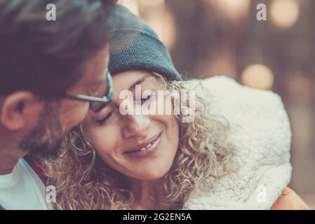 Romanticismo e tenerezza tempo per adulto giovane coppia insieme - ritratto di bella donna e uomo abbraccio e amore all'aperto con bokeh sfondo colorato Foto Stock