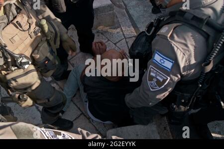 Un uomo palestinese detenuto alla porta di Damasco durante la visita del legislatore di estrema destra, Itamar ben-Gvir, che sostiene l'espulsione degli israeliani-arabi non sufficientemente fedeli ad Israele il 10 giugno 2021 a Gerusalemme Est, Israele. I tremori si sono scatenati dopo che il legislatore di estrema destra, Itamar ben-Gvir, accusato dalla polizia di agitare disordini a Gerusalemme, ha parlato fuori dalla porta di Damasco della Città Vecchia, il luogo degli scontri del mese scorso tra palestinesi e forze di sicurezza israeliane. Foto Stock