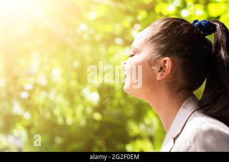 Donna che respira aria pulita con occhi chiusi Foto Stock