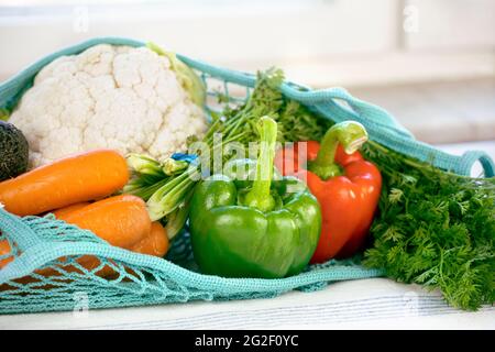 Primo piano di prodotti freschi in rete di pesce blu a maglia, riutilizzabile, sostenibile, eco-compatibile, terra giorno, senza plastica concetto. Verdure varie: Peperoni, Foto Stock