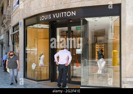 Valencia, Spagna. 10 Giugno 2021. Una donna che indossa un facemask come precauzione contro la diffusione del covid-19 camminare oltre il negozio Louis Vuitton. Credit: SOPA Images Limited/Alamy Live News Foto Stock