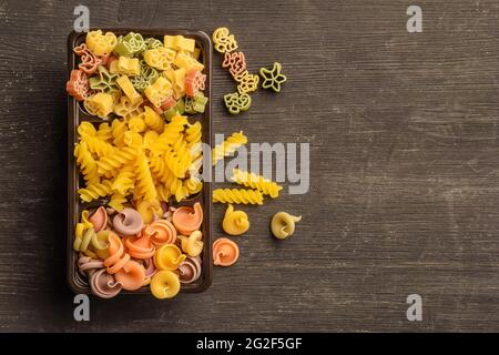 Diversi tipi di pasta cruda in una scatola sul tavolo Foto Stock