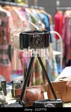 Vecchia fotocamera vintage sul treppiede in vendita in uno stand al Classic Car Boot sale a Granary Square a King's Cross London. Foto Stock