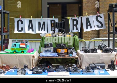 Vecchie fotocamere e obiettivi vintage in vendita in uno stand al Classic Car Boot sale a Granary Square a King's Cross London. Foto Stock