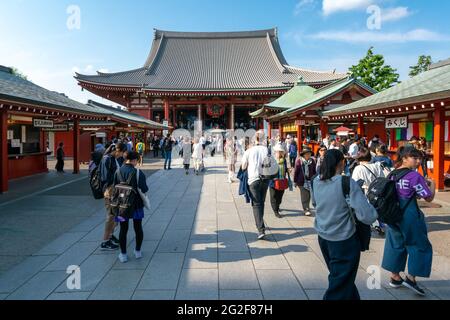 Tokyo, Giappone - 05.13.2019: Molte persone camminano verso l'edificio principale del complesso del tempio di Asakusa in una giornata di sole Foto Stock